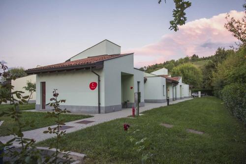 a white building with a red stop sign in the grass at Albavillage Hotel Wellness & Camping in Alba
