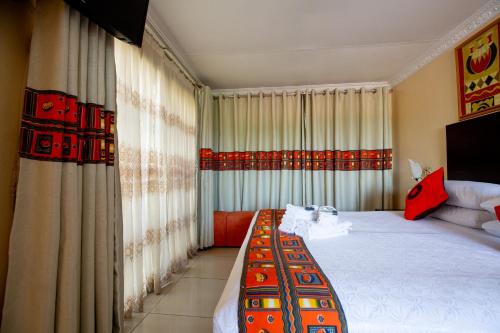 索韦托Emthonjeni Bed & Breakfast的一间带大床和窗帘的卧室