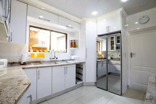 索韦托Emthonjeni Bed & Breakfast的带水槽和窗户的白色厨房