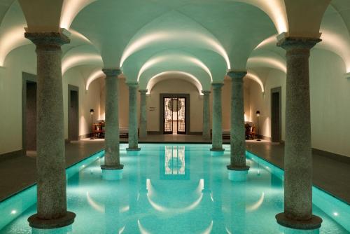 a swimming pool with columns in a building at Portrait Milano - Lungarno Collection in Milan