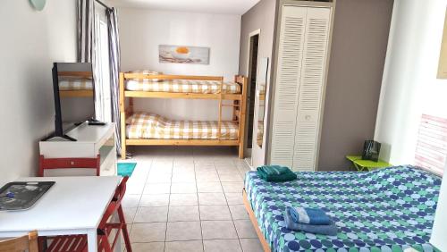 a bedroom with a bed and a desk and a television at LE TRANSAT 40m de la plage in Palavas-les-Flots