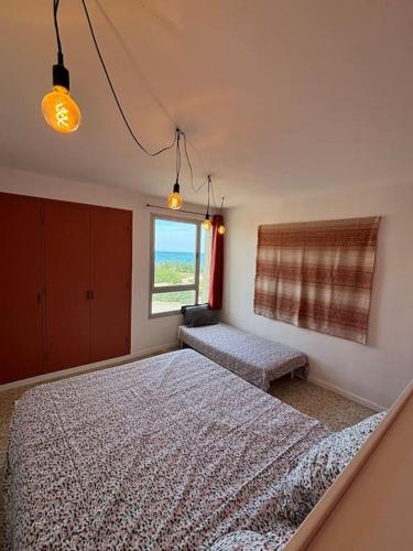 une chambre avec deux lits et une fenêtre dans l'établissement Le Saint-Ange, appartement accès direct à la plage, au Barcarès