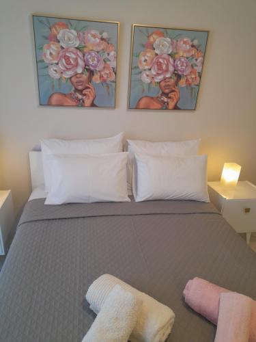 a bedroom with a bed with two pictures on the wall at Zozi's home N.MOYDANIA in Nea Moudania