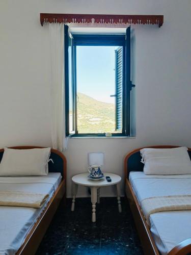 a room with two beds and a table with a window at Amersa's House in Skiros