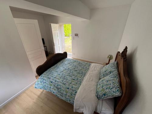 a bedroom with a bed with a wooden head board at LE PRESBYTERE in Rouperroux-le-Coquet