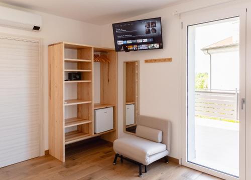 a room with a chair and a monitor on the wall at B&B Bagni di sole in Campo San Martino