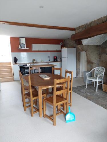 a kitchen with a wooden table and chairs at Ferme Auberge Linossier in Burdignes