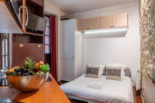 mały pokój z łóżkiem i miską owoców na stole w obiekcie Lavie Maison little Flat Le Marais w Paryżu