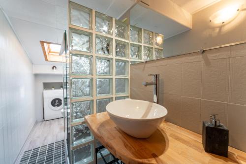 uma casa de banho com um lavatório numa mesa de madeira em [Asiago centro] Mansarda con Balcone e Giardino em Asiago