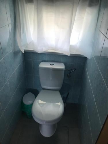 a bathroom with a white toilet and a window at Tanie Pokoje Kajetany in Kajetany