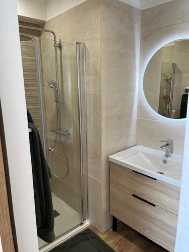 une salle de bain avec une douche, un lavabo et un miroir dans l'établissement Villa du sud, à Gardanne