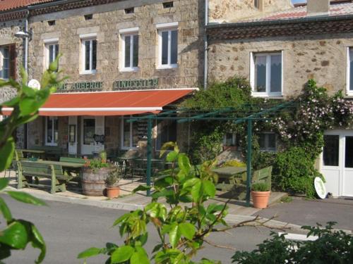 a building with a table and benches in front of it at Ferme Auberge Linossier in Burdignes