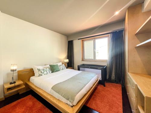 a small bedroom with a bed and a window at Casa Atlântico - 5 minutes from the beach in Viana do Castelo