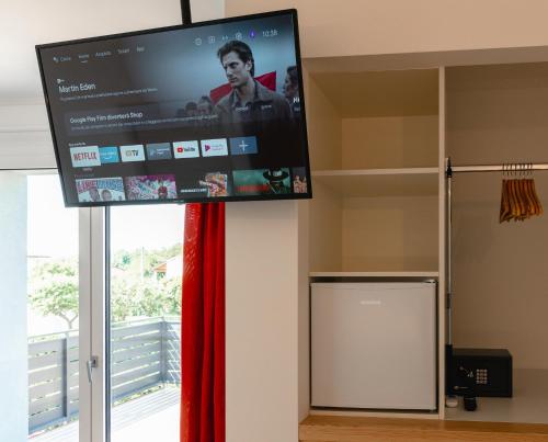 a flat screen tv in a room with a window at B&B Bagni di sole in Campo San Martino