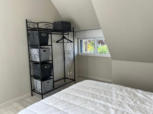 - une chambre avec un lit et une étagère avec des boîtes dans l'établissement 651 - Belle maison en pierre à 300m de la plage., à Erquy