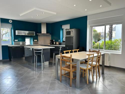 une cuisine avec des murs bleus et une table et des chaises dans l'établissement 651 - Belle maison en pierre à 300m de la plage., à Erquy