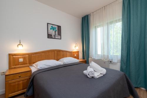 a bedroom with a bed with two towels on it at Maca Apartments & Suites in Trogir