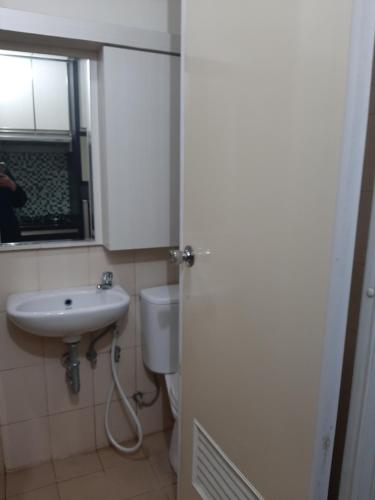 a bathroom with a sink and a toilet and a window at Apartemen Panoramic by Dio Property in Bandung