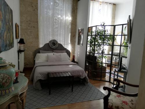 a bedroom with a bed with white sheets and a window at La clef de champs in La Romieu