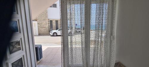 an open door with a curtain in a room at Bella Mare Luxury Apartments in Kalamaki Heraklion