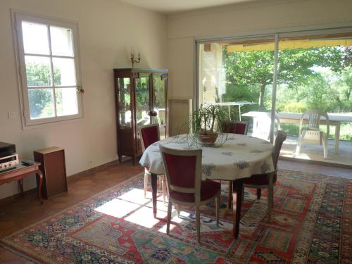 une salle à manger avec une table et des chaises sur un tapis dans l'établissement Au coeur du luberon, Grande villa avec piscine, et parc arboré, à Bonnieux