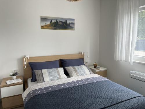 une chambre avec un lit avec des draps et des oreillers bleus dans l'établissement Villa Ispo Volta, à Posedarje