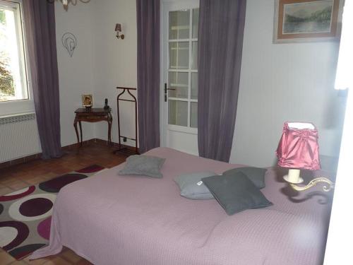 une chambre avec un lit avec des rideaux violets et une fenêtre dans l'établissement Au coeur du luberon, Grande villa avec piscine, et parc arboré, à Bonnieux