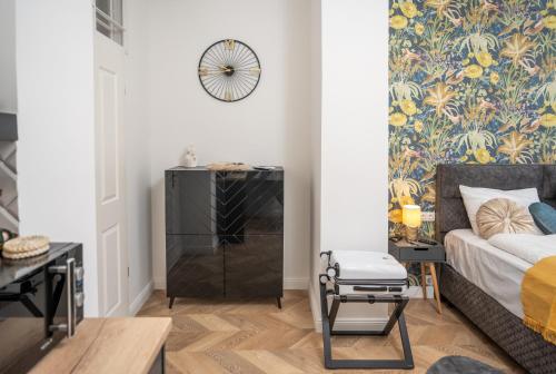 a bedroom with a bed and a wall with a floral wallpaper at V62 studio apartments- Downtown Sopron in Sopron