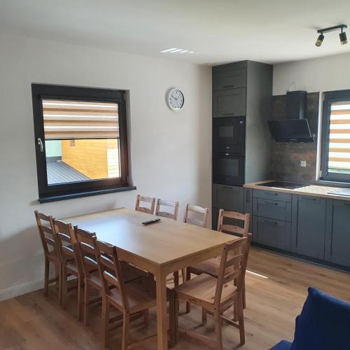 a dining room with a wooden table and chairs at Domki Dzika Orlica in Mostowice