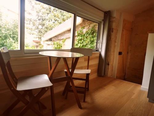 a table and chairs in a small room with a window at Gîte chaleureux à Cherveux in Cherveux