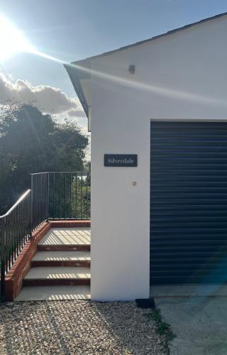 a white building with a door and a staircase at Studio apartment in Harefield in Harefield