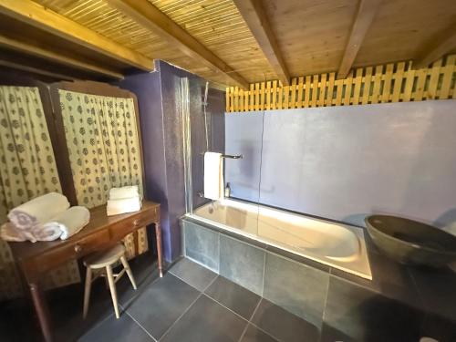 a bathroom with a tub and a table and a stool at Quinta da Peça Douro Wine Region Retreat, Private Pool Villa in Vila Real