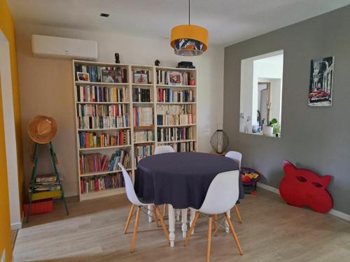 - une salle à manger avec une table, des chaises et des étagères dans l'établissement maison familiale, à Villevieille