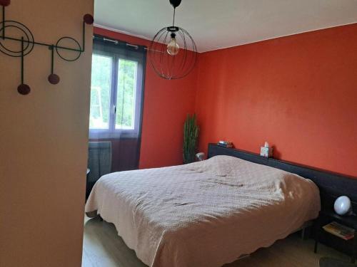- une chambre avec un mur orange et un lit dans l'établissement maison familiale, à Villevieille