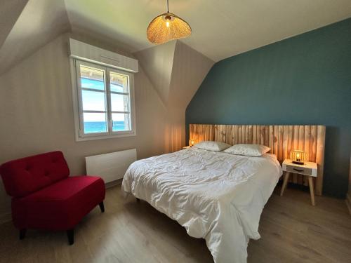 une chambre avec un lit et une chaise rouge dans l'établissement 708 - Maison Lanruen, les pieds dans l'eau., à Erquy