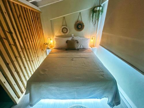 a bedroom with a bed with two lights on it at Gardy rooms in Nea Kalikratia