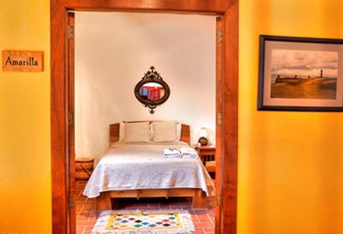 a bedroom with a bed and a mirror on the wall at El Zopilote Mojado in Guanajuato