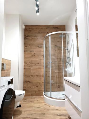 a bathroom with a shower and a toilet at AlfaHome Neopolis Parking in Łódź