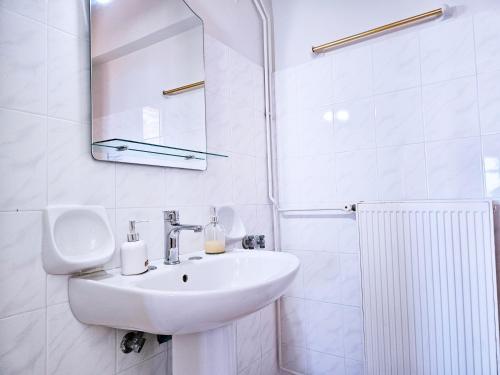 a white bathroom with a sink and a mirror at Ocea Retreat in Karlovasi
