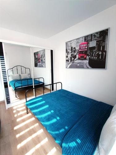 a bedroom with a blue bed and a red bus at AlfaHome Neopolis Parking in Łódź