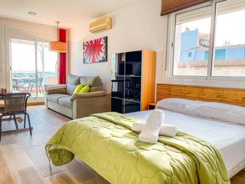 a bedroom with a bed and a living room with a couch at Attic by Unik Vacation in Tarragona