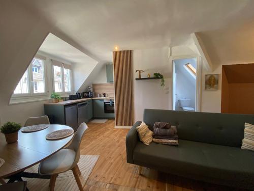 un salon avec un canapé vert et une table dans l'établissement L'Écrin de Verdure -334, à Rouen