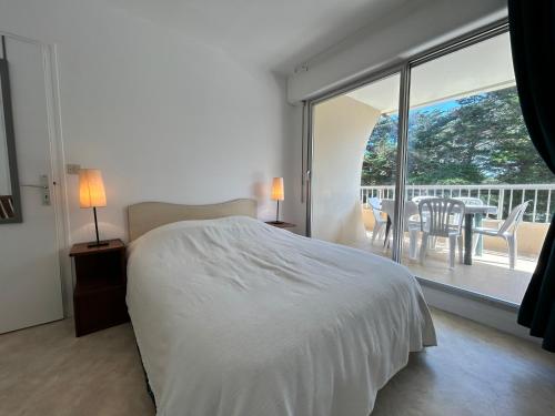 une chambre avec un lit et un balcon avec une table dans l'établissement 401 - Appart T2 à 50m de la belle plage de Caroual, à Erquy