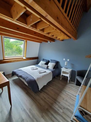 sypialnia z dużym łóżkiem i oknem w obiekcie camping hôtel les airelles w mieście Saint-Cirgues-en-Montagne