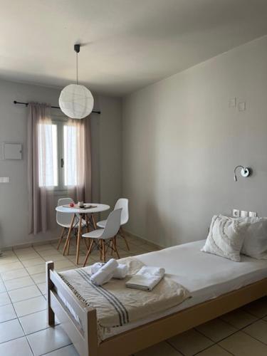 a bedroom with a bed and a table and chairs at Thalia Bloom Villa Apartments in Agia Pelagia
