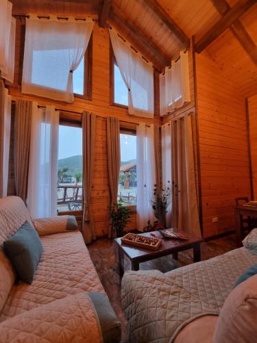 a living room with two beds and windows at Casa rural Cabaña de la Huerta in Navahermosa