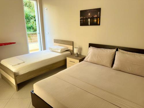 a bedroom with two beds and a window at Sunny Coast Apartments in Sarandë