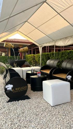 a group of couches and tables under a tent at Hotel Bar Restaurante IL Rifugio in Poás