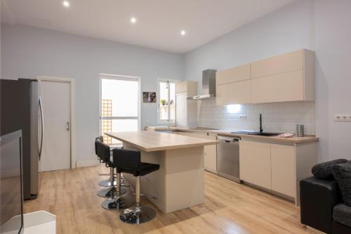 a kitchen with white cabinets and a table and chairs at Centrico duplex con parking in Tenerife
