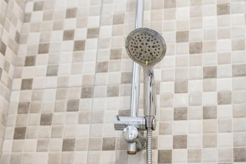 a shower with a shower head on a tiled wall at Centrico duplex con parking in Tenerife